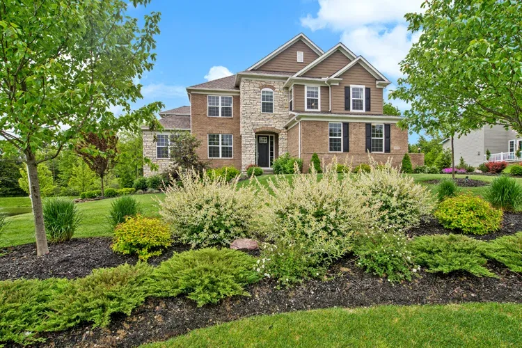 brick home with front yard nicely maintained